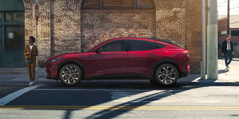 Woman standing in front of red Ford Mustang Mach-E