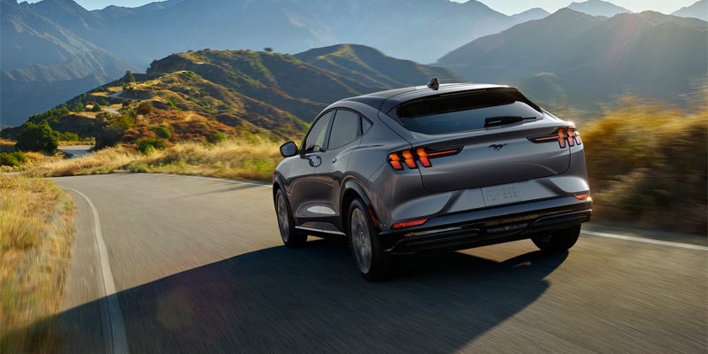 Gray Ford Mustang Mach-E driving on a mountain road