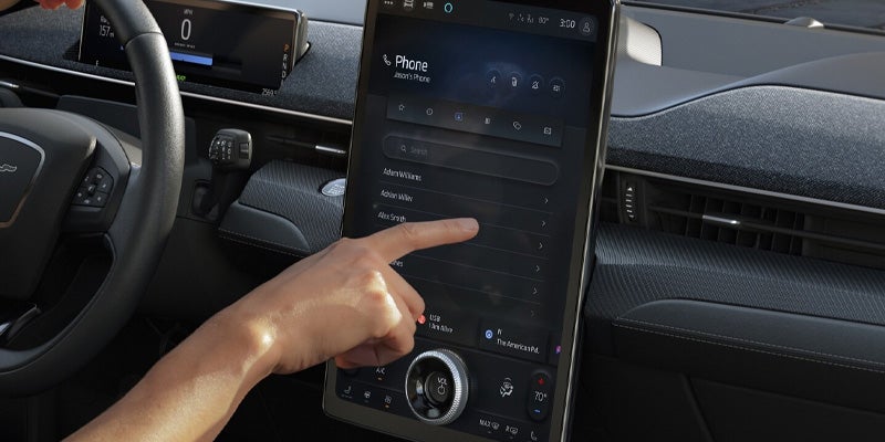 Person interacting with Ford Mustang Mach-E touchscreen